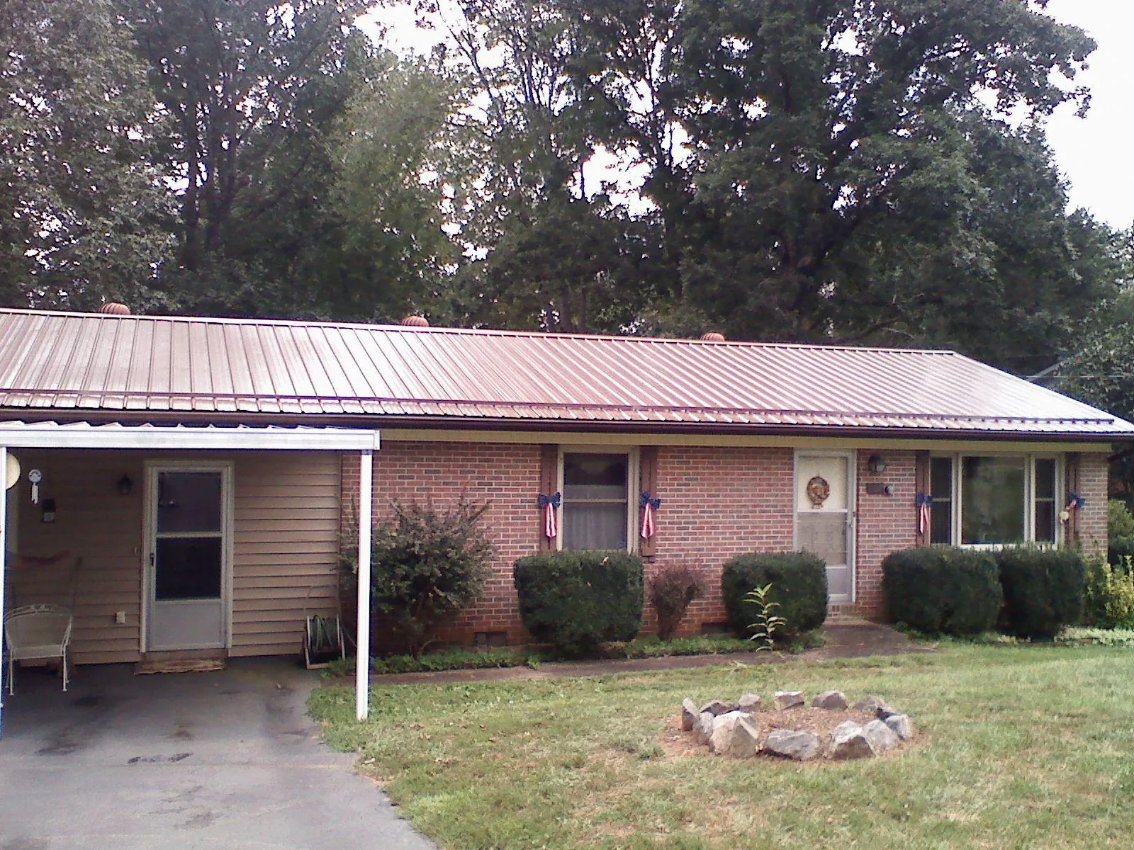Bronze metal roof and carport on a brick ranch home — Roof Repair work by our crew in Mad River